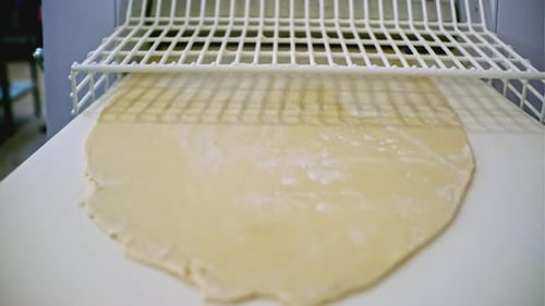 Rolling Out Dough on Industrial Machine Clip Sheeter Machine for Dough at Industrial Enterprise