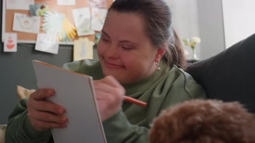 Young Woman Drawing in Notebook at Home