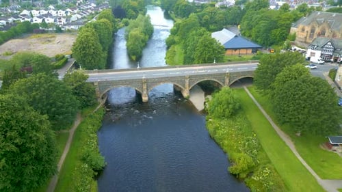 Aerial Drone shot flying northwest over the River Tweed towards the Tweed Bridge in the town of Peeb