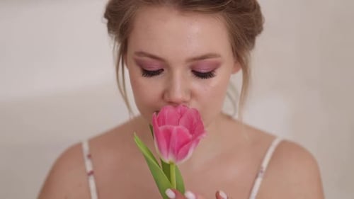 Woman Smelling Pink Tulip Flower Close Up