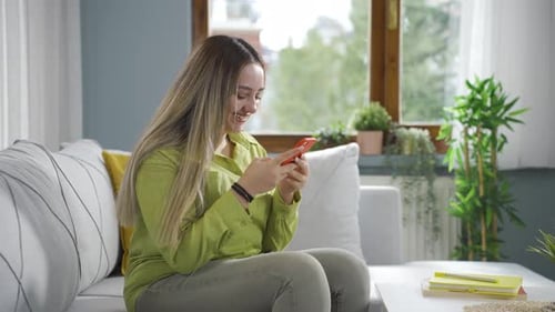 Woman laughing at phone message.