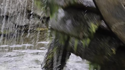 Nahaufnahme eines Wasserrads auf einem Fluss in der Natur. Das Mühlrad dreht sich unter einem Strom
von