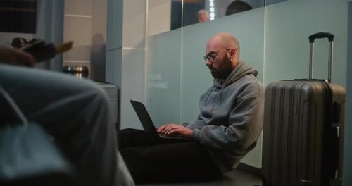 Airport Terminal Man Doing Remote Work on Laptop Sitting on the Floor in Airline Hub Lounge