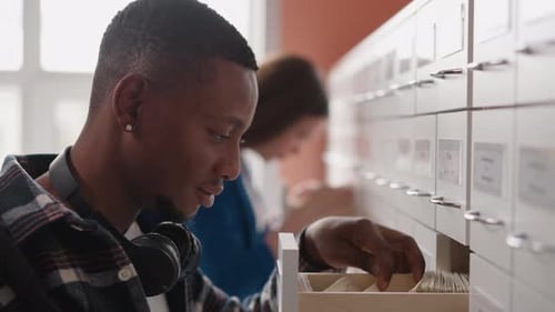 Man Goes Through Drawer of Forms in Paper Storage