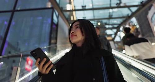 Japanese woman on city escalator with phone, internet and connection on morning commute