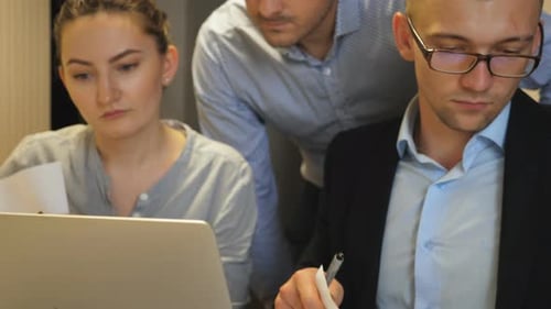 Young Coworkers Examining Statistical Data Information on Laptop at Office Professional Managers