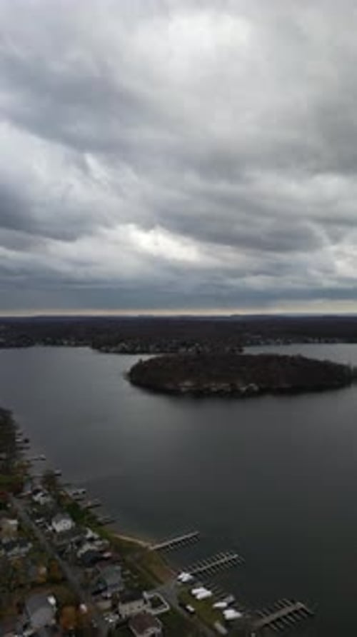 Low altitude drone flight over Larchmont’s lakeside showing a bay with houses, piers, and rich