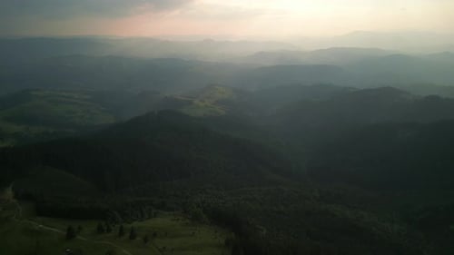 Flying Over Green Forest at Cloudy Day with the Mountains on Horizon with Glowing Clouds Carpathian