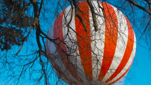 Hot air balloon in the park against the sky