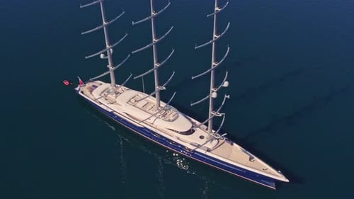 Black Pearl mega sail yacht moored in calm blue water, aerial