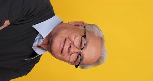 Vertical clip. Close up, portrait of older man smiling and looking at the camera.