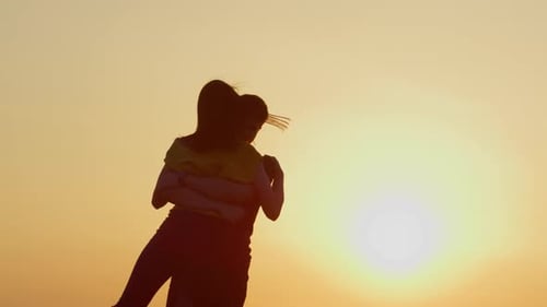 Silhouette of Happy Couple Embracing at Sunset