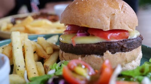 Closeup Cinematic Shot of a Burger and Fries in a Restaurant Huge Plate of Beef Cheese Burger and