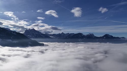 snowy churfirsten ridges rise above a vast rolling cloud ocean under a bright sky