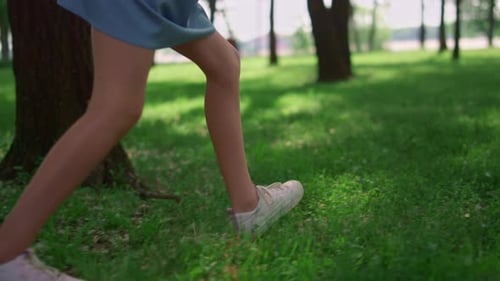 Happy children run on green grass meadow enjoying outdoors in summer sunlight