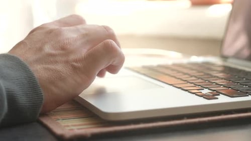 Dedos masculinos se movem sobre o touchpad do laptop no escritório