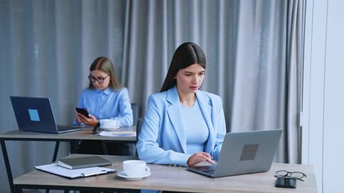 Busy employees working at office sitting at desks in front of computers.