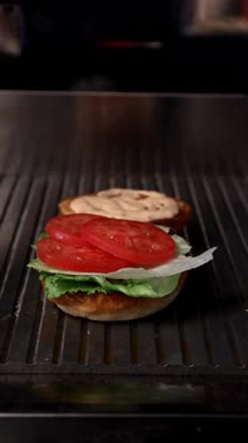 Burger Being Prepared with Condiments and Toppings