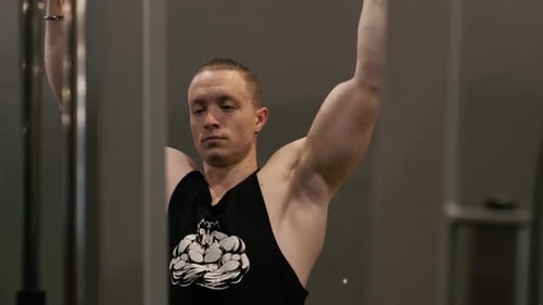 Hombre entrenando en el gimnasio y haciendo ejercicio con pesas en el gimnasio