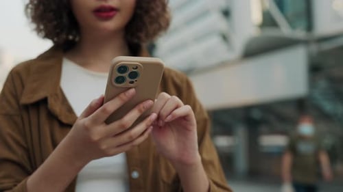 Vista de cerca de las manos que sostienen el teléfono celular y chatean en las redes sociales mientras están de pie al aire libre