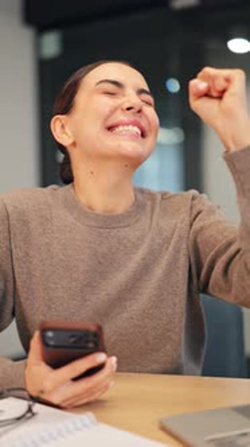 Excited Woman Celebrates Success at Her Desk
