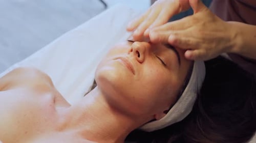 Woman receiving a facial massage at spa