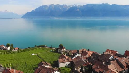 Aerial drone capturing townscape by calm lake during daytime