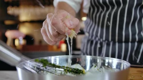 Chefkoch bereitet Gourmet-Salat mit Zitronenpresse zu
