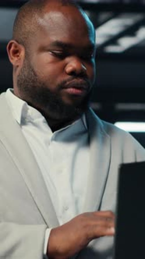 Vertical Video Data Center System Administrator Coding on Laptop Doing Software Updates