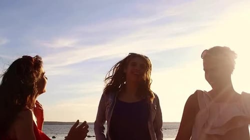 Three Women Cheering Together on a Beach