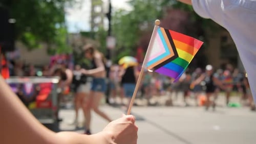 Waving Pride Flag at Colorful Street Celebration