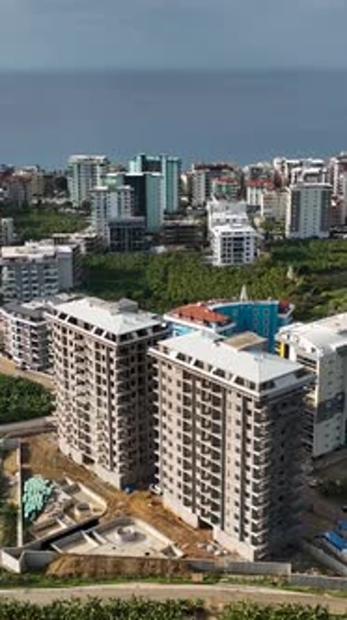 Vídeo vertical: renovación de fachadas, trabajadores de la construcción en andamios, rica infraestructura vibrante