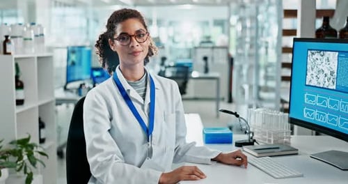 Woman Scientist Typing and Smiling in Bright Lab