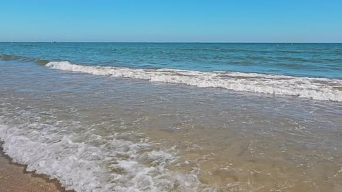 Wave Approaching Sandy Beach Gentle Waves Rolling Onto the Shore of a Sandy Beach with Clear Blue