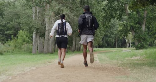 Fit couple running in a forest and on a dirt road path