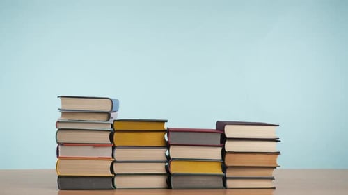 Stop Motion of Colorful Old Books Stacking Up and Vanishing on Wooden Table