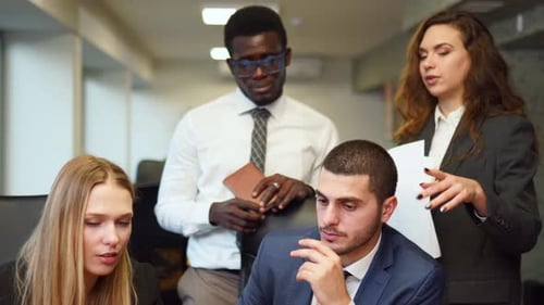Diverse Office Corporate Workers Discuss Project on Laptop Display in Office Multiethnic People