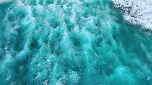 Mesmerizing view of foamy waves on the turquoise waterscape.