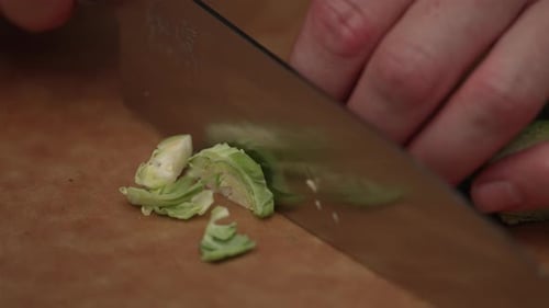 Cutting Brussels Sprout With Knife On Wooden Board. close up, slow motion