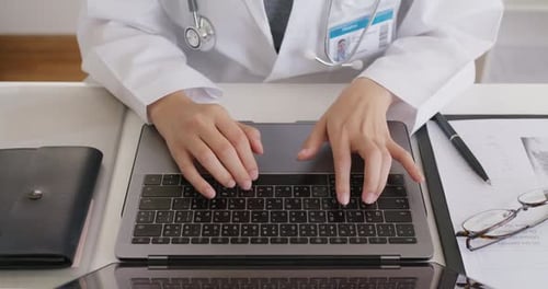 Médecin saisissant les dossiers médicaux des patients sur un ordinateur portable
