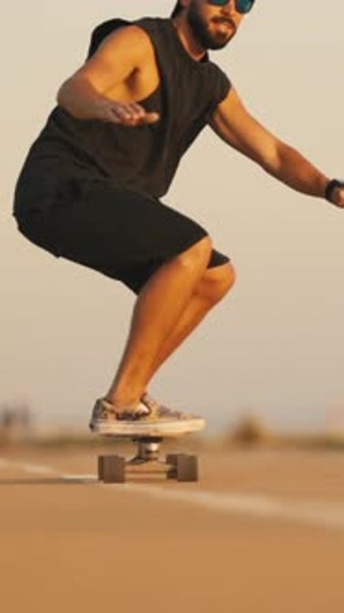 Adult Bearded Man Skateboarding on the Street on His Knees