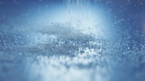White sugar pours over blue countertop