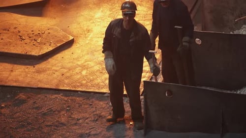 Workers Handling Molten Metal in a Busy Foundry Showcasing Skills and Techniques Stock Clip