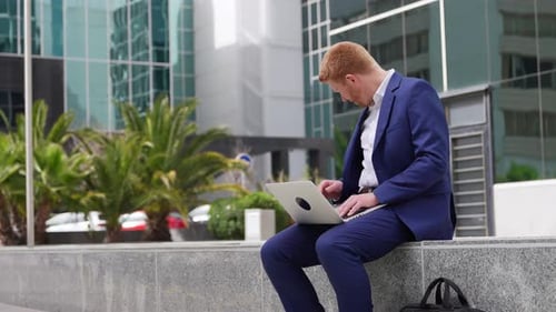 Young Professional Works on Laptop, Answers Phone