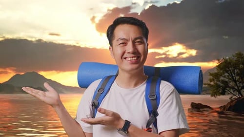 Close Up Of Asian Male Hiker Smiling And Pointing To Side At A Lake