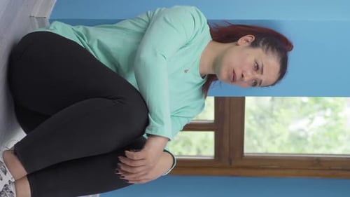 Woman Sitting on the Floor Hugging Knees