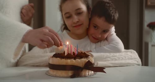 Lighting Candles on Birthday Cake with Children Waiting