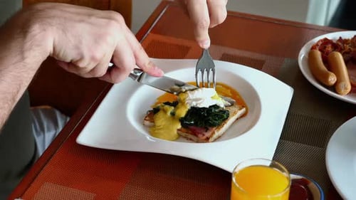 Breakfast of Eggs Benedict on Toast with Juice