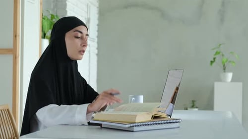 An Arab Student Studying at an International University Uses a Laptop Remotely Via the Internet