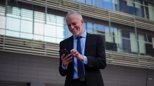 Man in Suit Using Mobile Phone in City